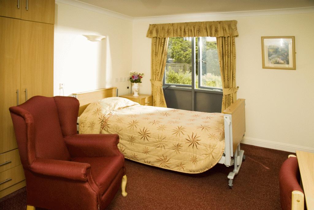 care home bedroom with red and gold furniture