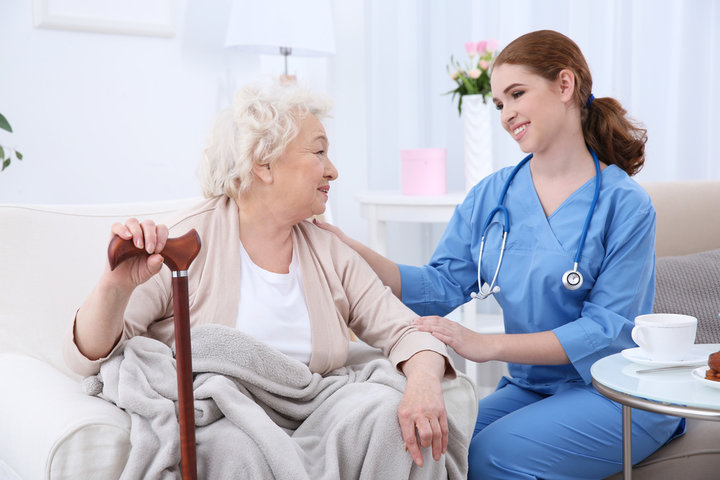 nurse speaking with woman in a light room