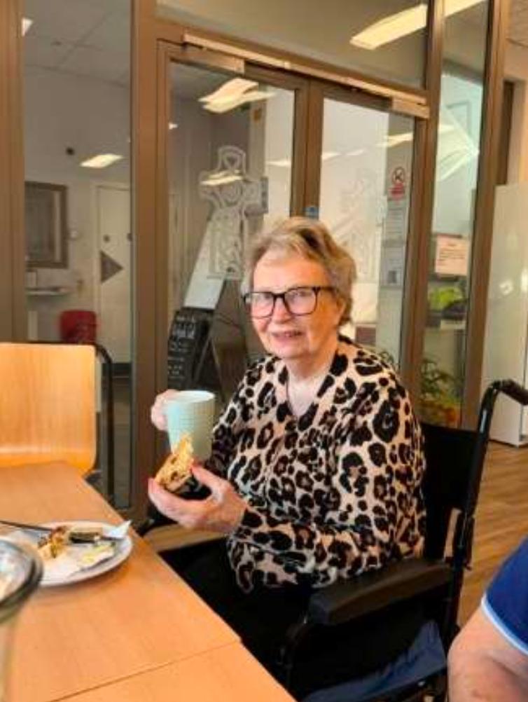 elderly woman smiling in a garden centre cafe