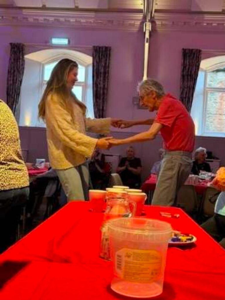 resident and staff member dancing in local seniors club